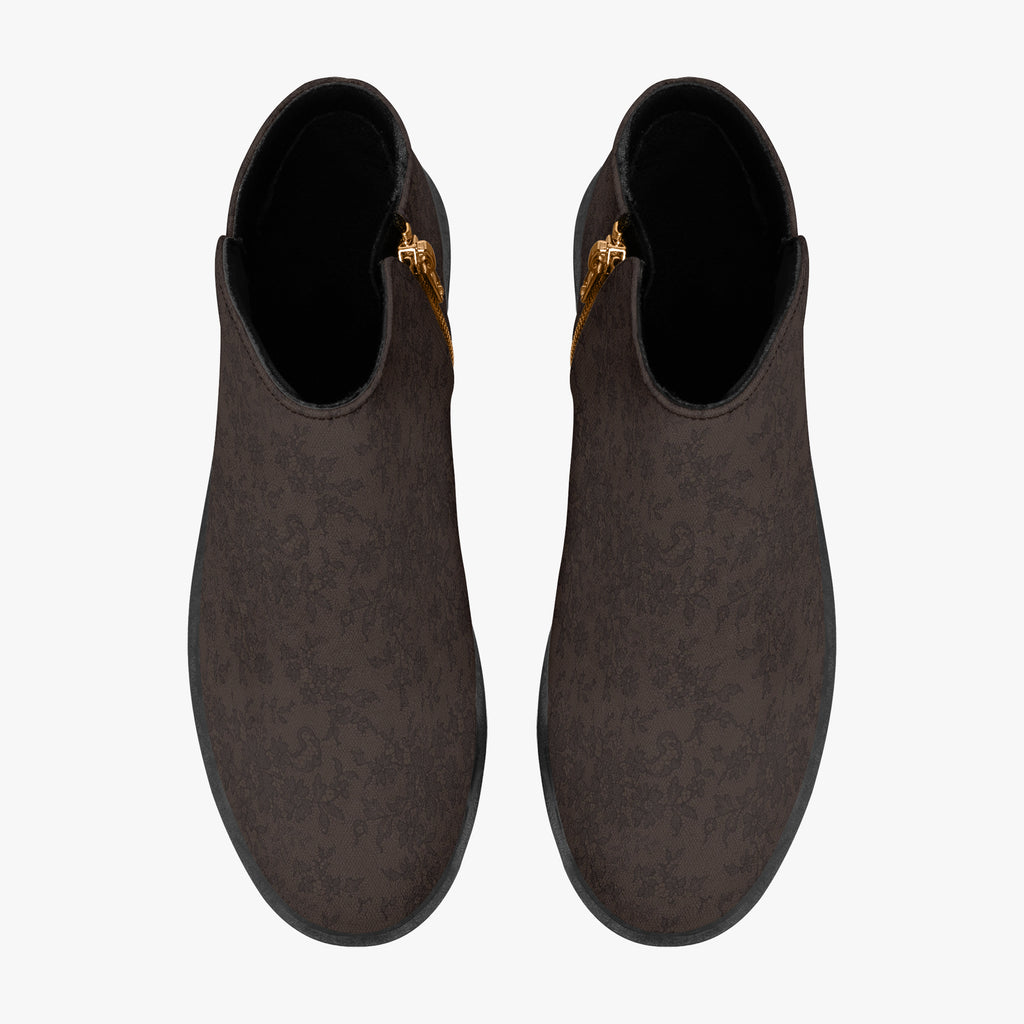 Dark brown floral lace ankle boots with chunky black heels and gold side zippers, top view.