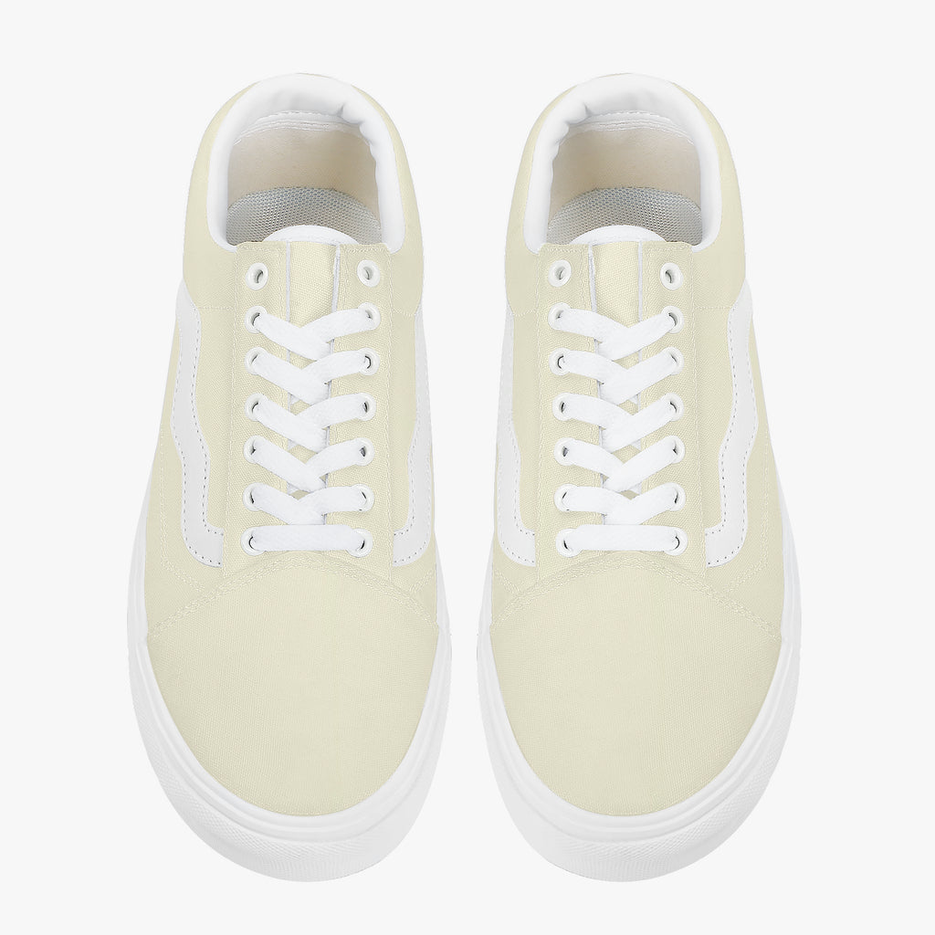 Pale yellow low-top canvas sneakers with white laces and thick white rubber soles.