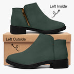 Dark green textured ankle boot with chunky black heel and gold side zipper on brown box.
