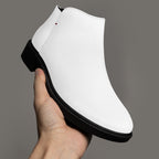 Modern white slip-on bootie with chunky black heel and subtle red accent stitch.