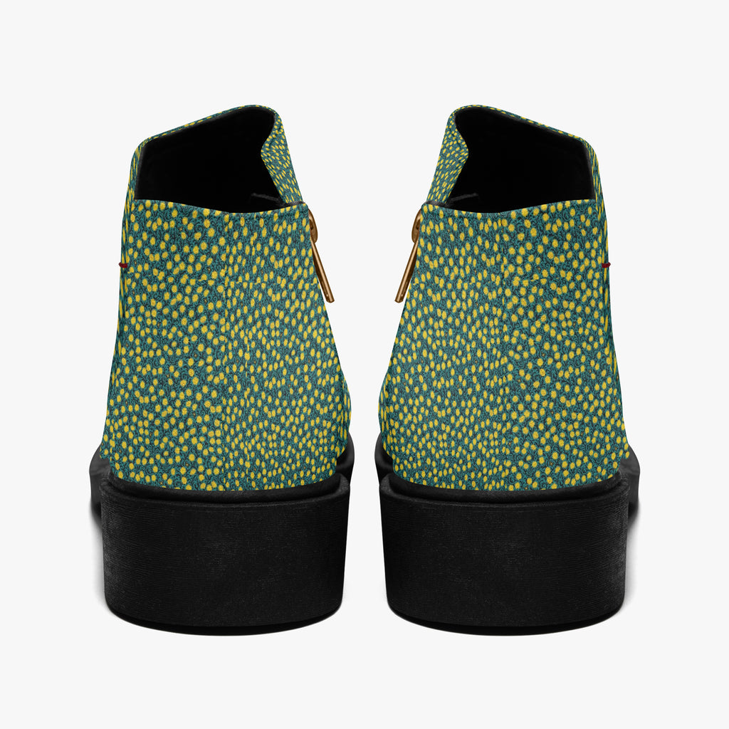 Teal ankle boots with sunny yellow polka dots, chunky black heels, and side zippers, rear view.