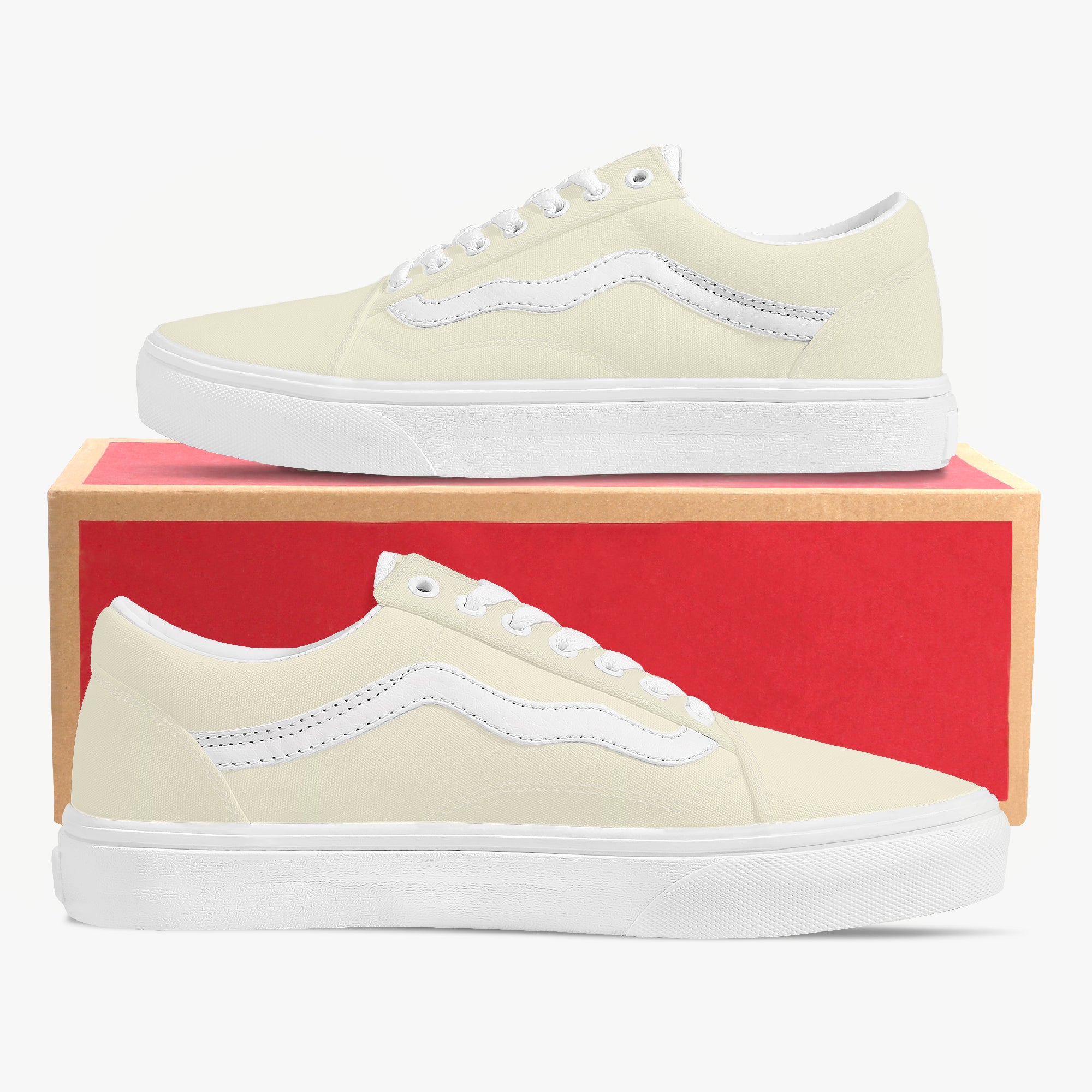 Pale yellow low-top canvas sneakers with white laces and thick white rubber soles, displayed on a red and brown shoe box.