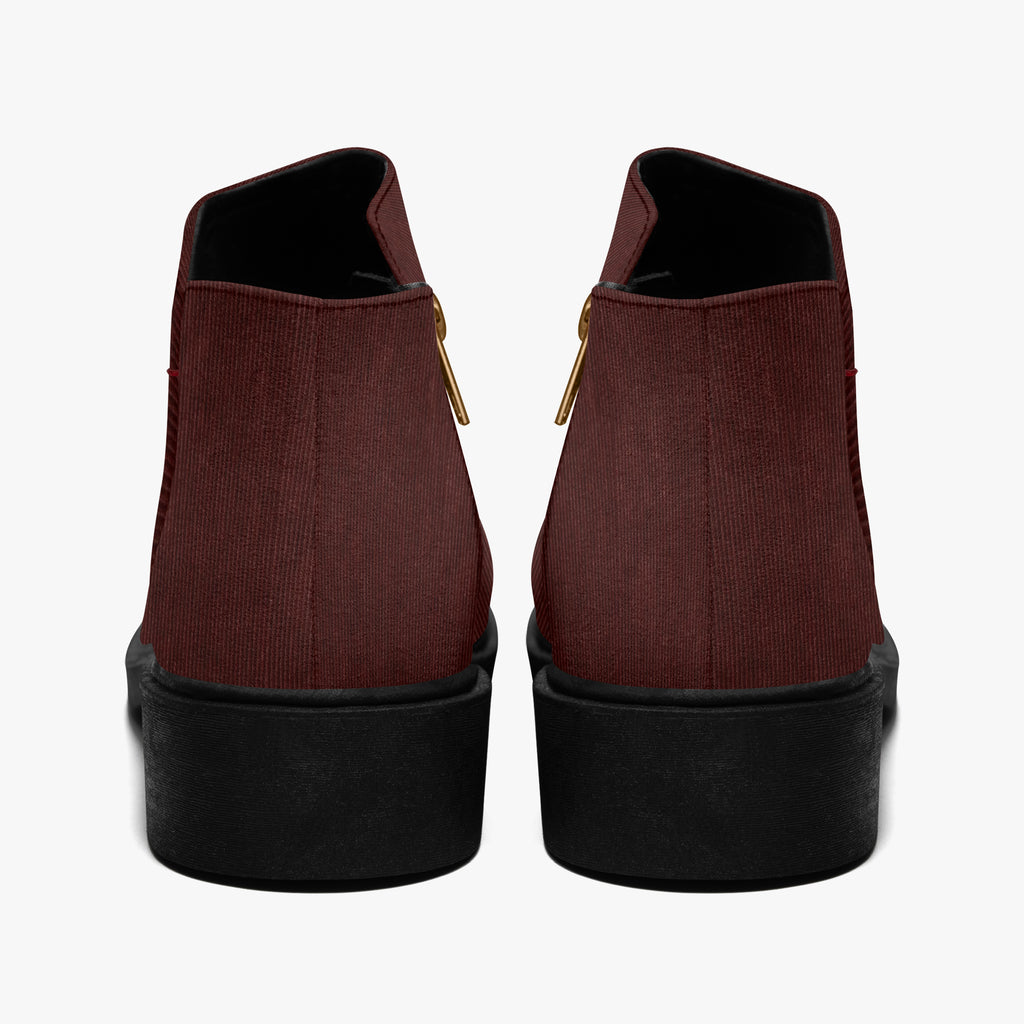 Pair of burgundy corduroy ankle boots with chunky black heels and visible gold zippers on the sides.