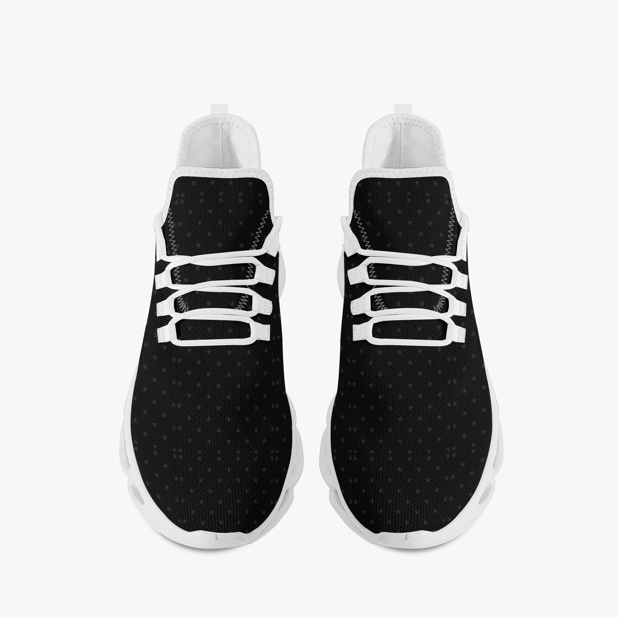 Black speckled knit sneakers with white laces and white rubber soles, viewed from above.