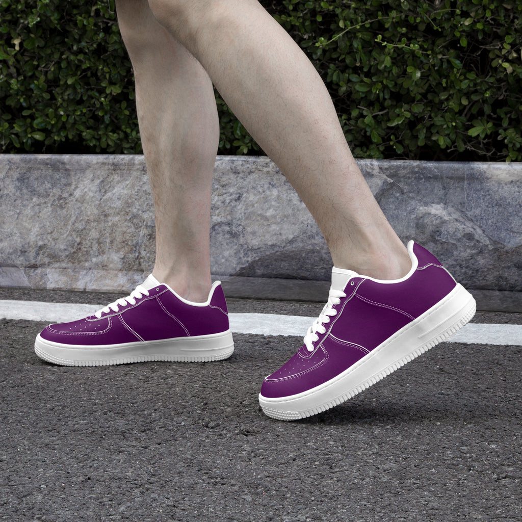 Low-top purple leather sneakers with white laces and thick white rubber soles on model feet.