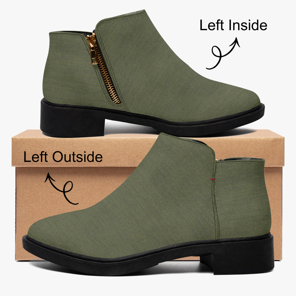 Olive green textured ankle boot with chunky black heel and gold side zipper on brown box.